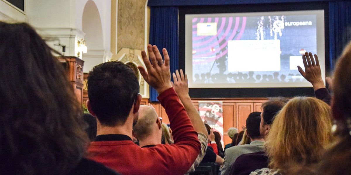 People raising hands at a conference