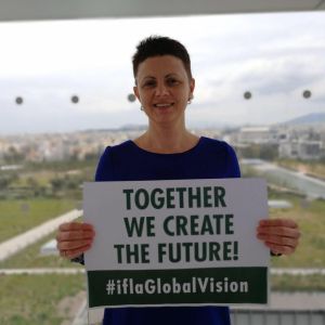 Kristīne Pabērza Ramiresa holding sign saying together we create the future #iflaGlobalVision