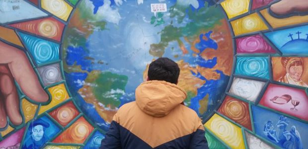 A person looks at a mural of the world