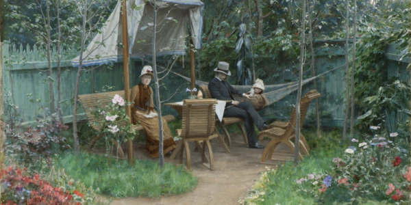 A woman, man and child sitting in a garden