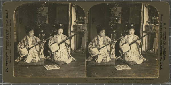 Two seated women play stringed instruments