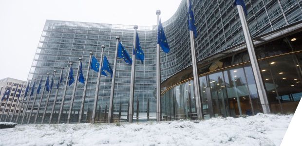 A snow covered building with EU flags outside