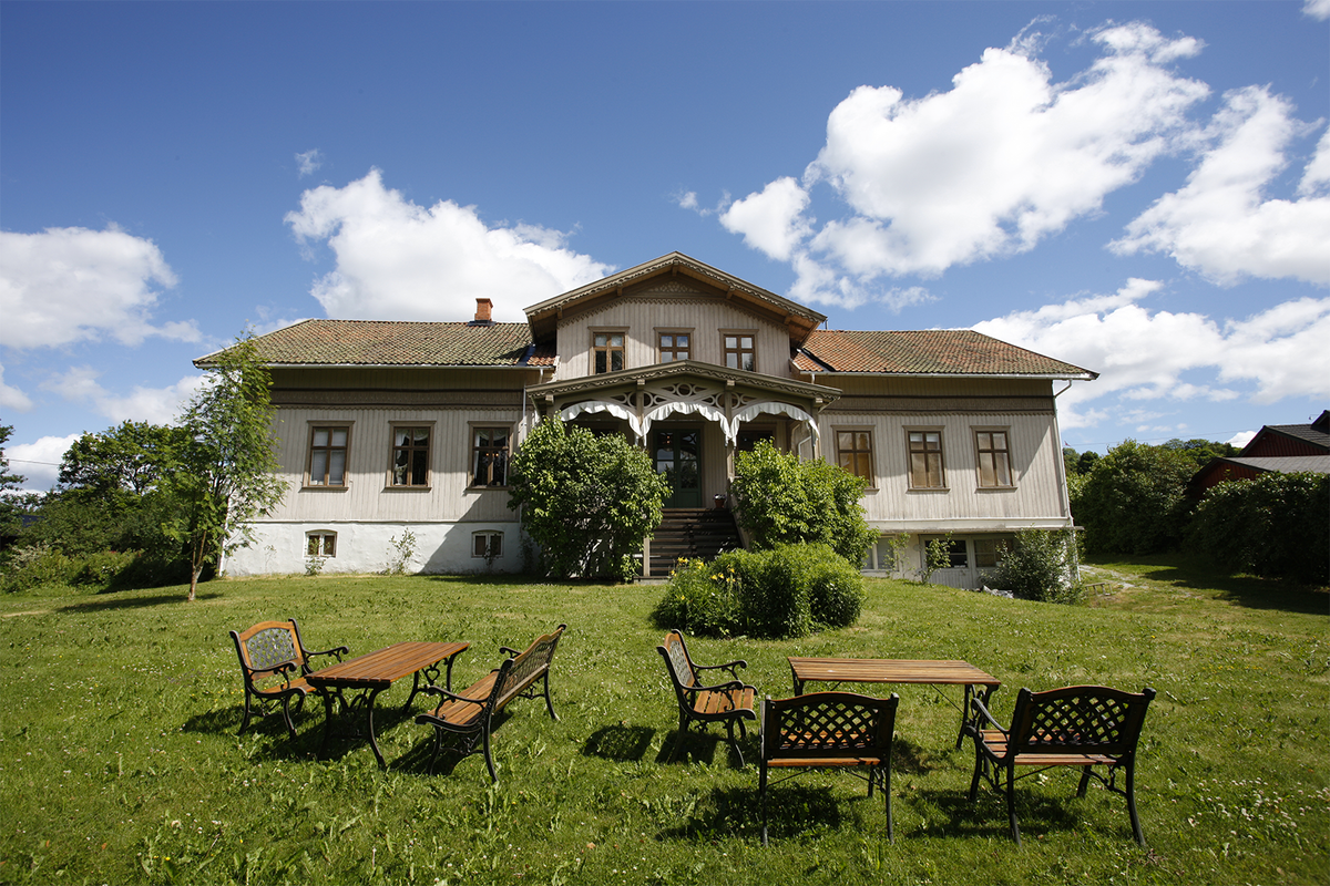 A large house with tables and chairs placed outside