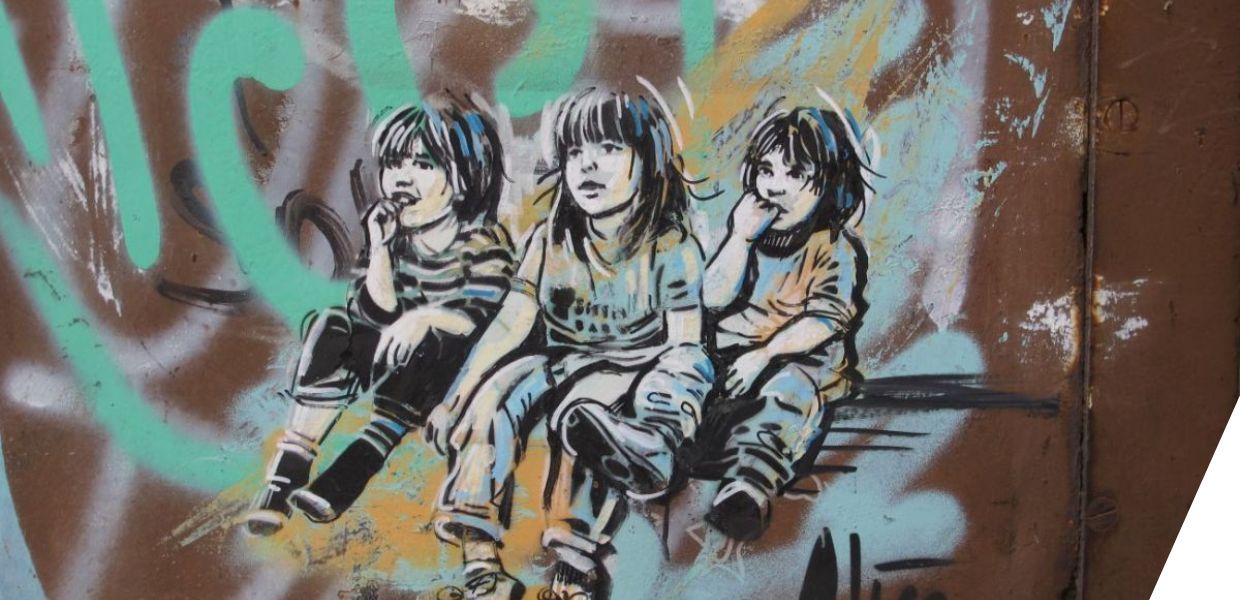 Painting of three seated children against graffiti 
