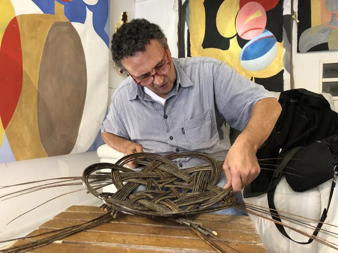 Portrait of Nico Solimano in his workshop, weaving a basket