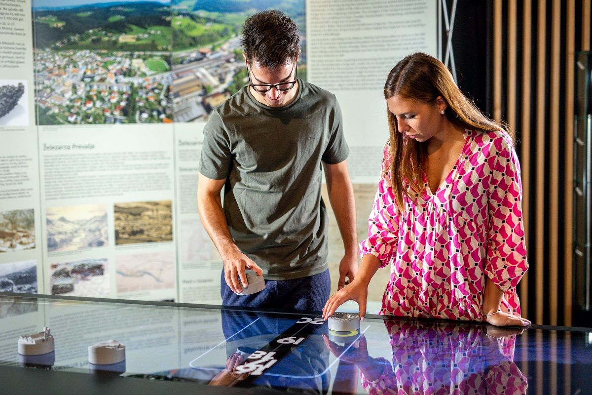 Two people in a museum looking at an interactive screen