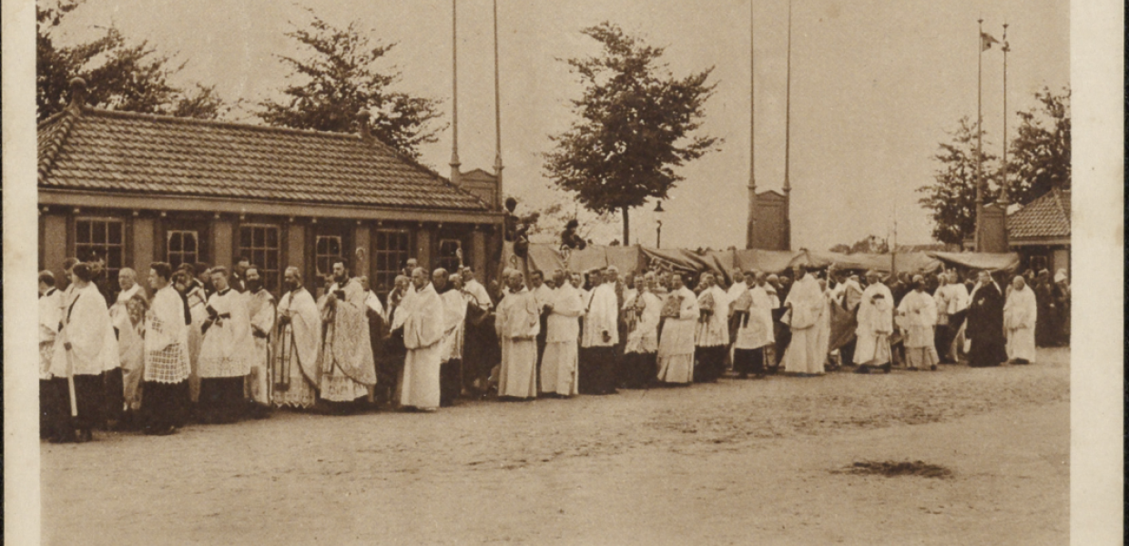 Black and white postcard of a row of priests