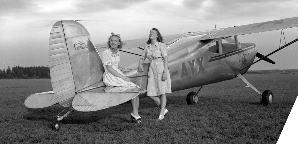 Two young women sat on the end of a plane