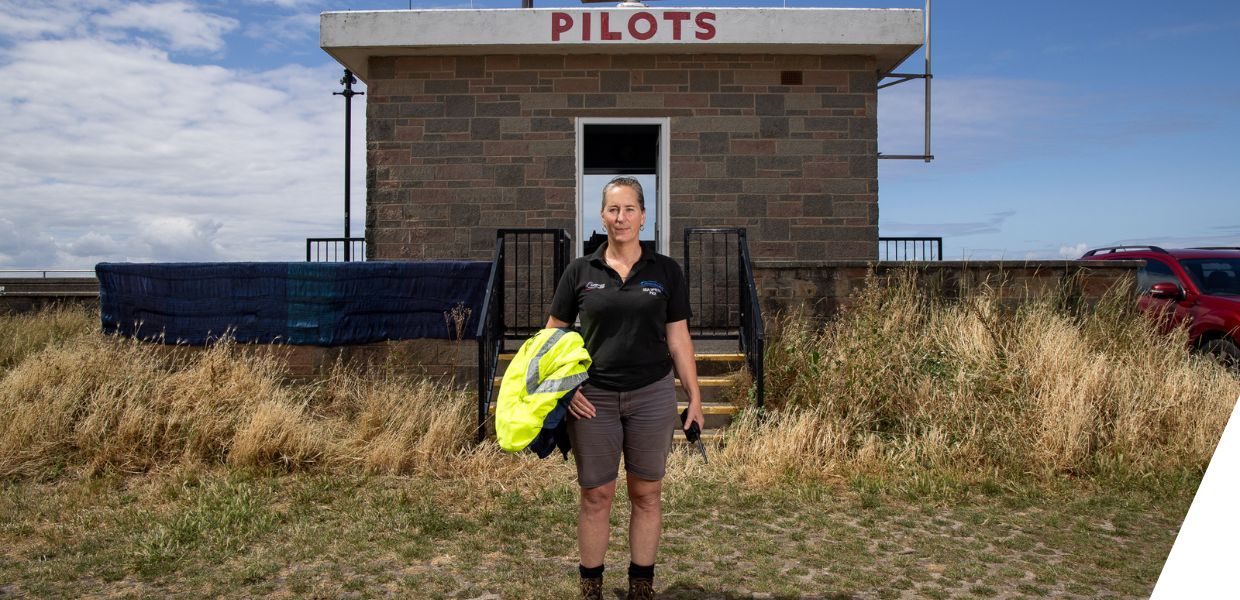 A woman standing in front of a building that says pilots in a sign over it
