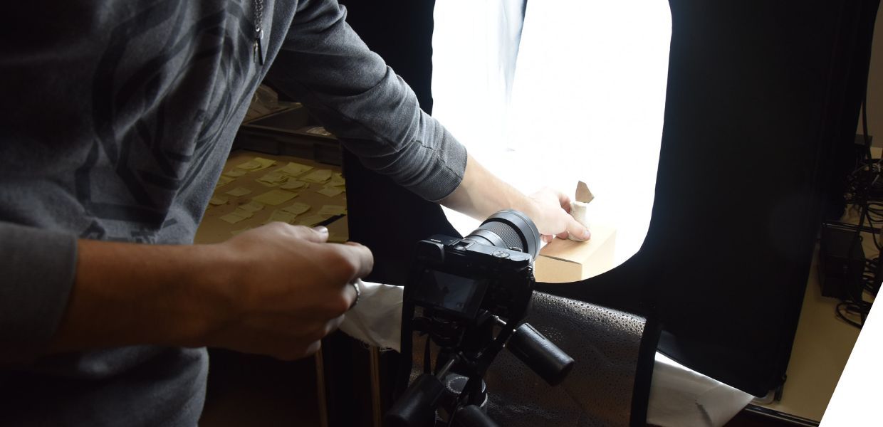 A pottery shard set up within a lightbox, with a camera facing it