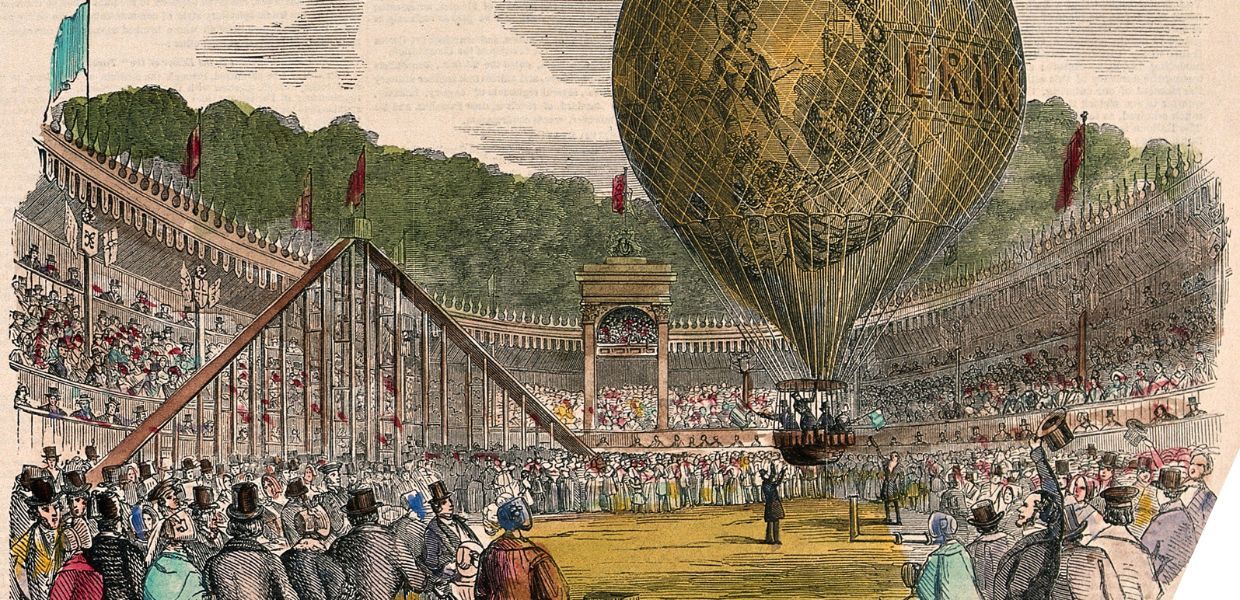 Large crowds of people have gathered to watch a hot-air balloon take off. Coloured wood engraving.