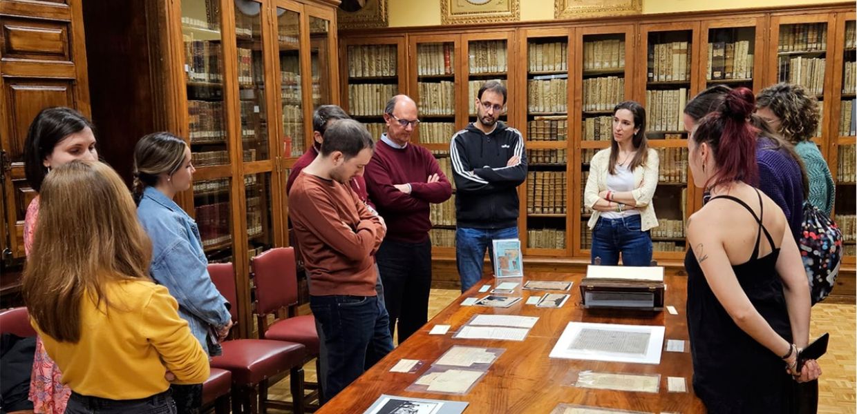 Participants visit Spain&#039;s National Archive, viewing documents on a large table 